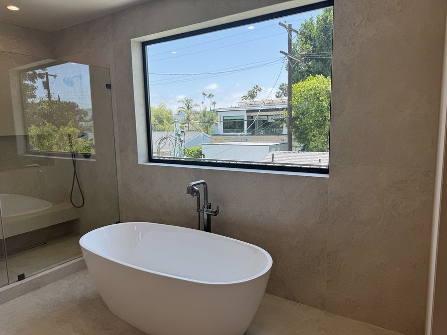 Freestanding tub in a modern primary bathroom by Coastline DC