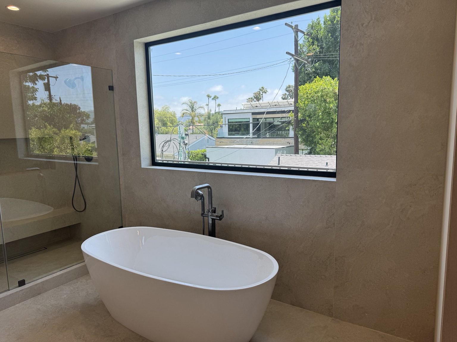 Freestanding tub in a modern primary bathroom by Coastline DC
