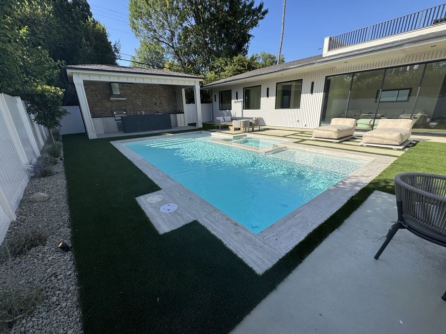 Rectangular swimming pool with turf and stone coping by Coastline DC