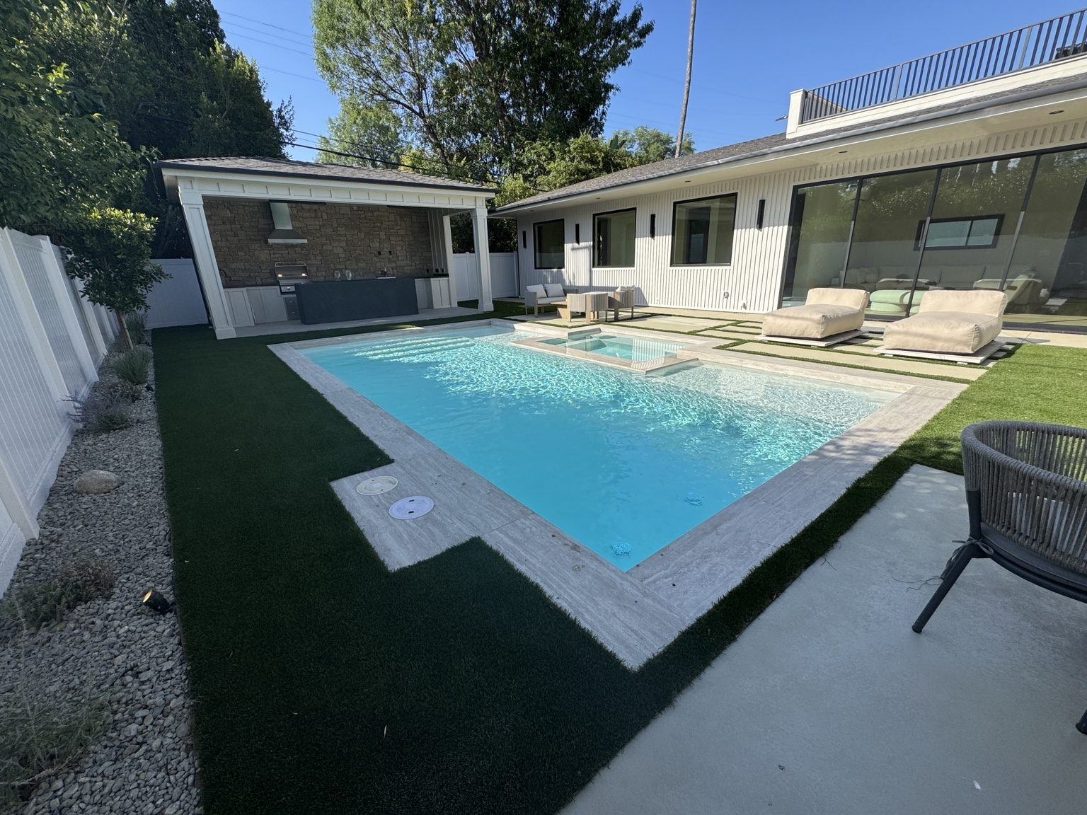 Rectangular swimming pool with turf and stone coping by Coastline DC